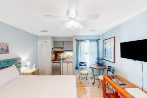 Una sala de estar con una cama y una cocina. en The Inn at St. Thomas Square #1202c, en Panama City Beach