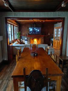 a dining room with a large wooden table and a fireplace at Alojamiento Punta Arenas in Punta Arenas