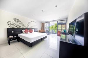 1 dormitorio con 1 cama grande y TV en Tanoa Tusitala Hotel, en Apia