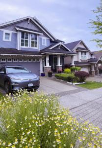Derbyshire House في كوكاوتلام: سيارة متوقفة أمام منزل به زهور