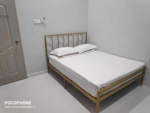 un lit avec des draps blancs et des oreillers blancs dessus dans l'établissement Villa Gong Badak, Kuala Terengganu, à Kuala Terengganu 12 autres photos