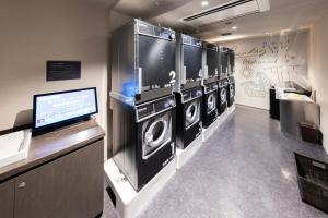 a laundry room with four washing machines and a tv at Tokyo Bay Shiomi Prince Hotel in Tokyo