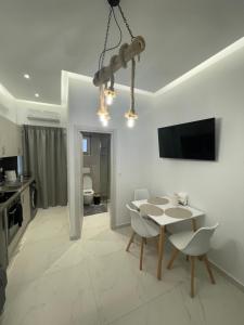 a white dining room with a table and chairs at Cozy City Center Apartment in Rhodes Town +1 photo