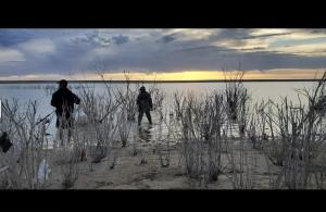 two people are standing on a beach near the water at RV Sites For Rent -Power-Water-Sewer-Wifi in Eads