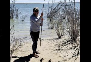 a woman standing on the beach holding a stick at RV Sites For Rent -Power-Water-Sewer-Wifi in Eads +2 photos