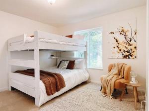 a bedroom with a white bunk bed and a chair at Jaw Drop View! Mt Hood! Fire Pit, Family Friendly in Underwood