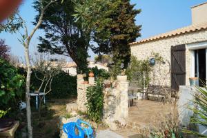 une cour avec une clôture en pierre et une maison dans l'établissement Chez Isabel à Mèze, à Mèze