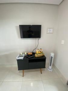 a room with a table with a tv on a wall at Apt Alto da Serra Villas - Bananeiras in Bananeiras