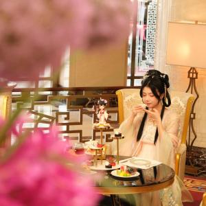 una mujer sentada en una mesa comiendo comida en China World Hotel, Beijing en Pekín