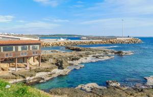 a house on the rocks next to a body of water at Nice Apartment In Isola Di Capo Rizzuto in Ovile la Marinella