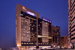 wysoki budynek w mieście w nocy w obiekcie Marriott Executive Apartments Downtown, Abu Dhabi w Abu Zabi