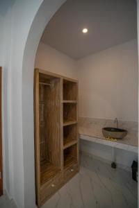 a bathroom with a sink and a wooden cabinet at The Uma Canggu in Canggu