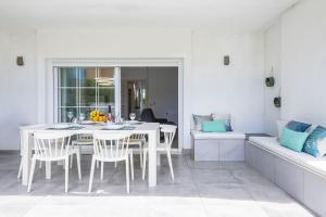 ein weißes Esszimmer mit einem weißen Tisch und Stühlen in der Unterkunft Las Gemas - Chalet adosado en urbanización cerrada in Peñíscola