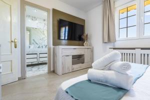ein Schlafzimmer mit einem TV und Handtüchern auf dem Bett in der Unterkunft Las Gemas - Chalet adosado en urbanización cerrada in Peñíscola