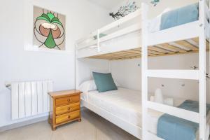 ein Schlafzimmer mit einem Etagenbett und einem Holzschreibtisch in der Unterkunft Las Gemas - Chalet adosado en urbanización cerrada in Peñíscola + 39 Fotos