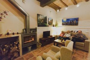 a man and a woman sitting in a living room with a fireplace at Casa Etxalde in Camprodon