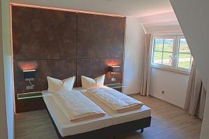 a bedroom with a bed with a large headboard at Truschwende 4 in Bad Wurzach