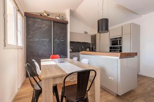 a kitchen with a table and a black chalkboard at Belle maison climatisée - MEET - Aeroscopia - TRAMWAY in Aussonne