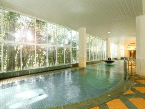 a swimming pool in a building with a large window at Notoya in Komatsu