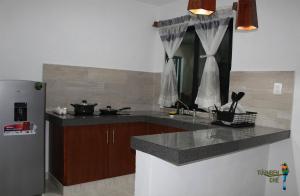 a kitchen with a counter top and a refrigerator at Departamentos Túumben Ché in Valladolid