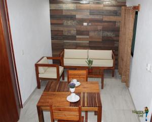 a living room with wooden tables and benches at Departamentos Túumben Ché in Valladolid