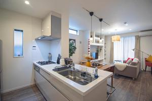 Una cocina con fregadero y una sala de estar. en -旅time 小路東- Koji Higashi 車庫付き戸建 4LDK, en Osaka