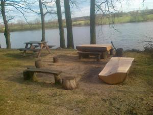 a group of picnic tables next to a lake at Chaty U Žabáka in Netolice