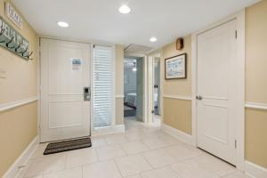 a hallway with white doors and tile floors at 2024 Beach Wood in Amelia Island