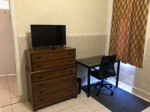 einen TV auf einer Kommode mit einem Schreibtisch und einem Stuhl in der Unterkunft Private 1-bedroom apartment only 15 minutes to New York City Manhattan in Union City + 1 Foto