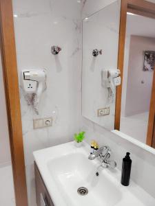 La salle de bains blanche est pourvue d'un lavabo et d'un miroir. dans l'établissement Super Apartement Totalement neuf a Marjane M2, à Tanger