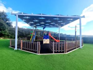 a playground with a swing set on a green lawn at Villa Marcia Home - Nature, Golf, Beaches-Lagos in Portimão