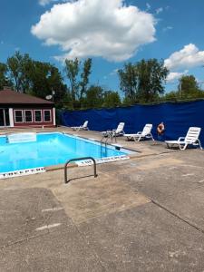 a swimming pool with chairs and a blue fence at Anchor Motel in Niagara Falls