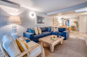 ein Wohnzimmer mit einem blauen Sofa und einem Tisch in der Unterkunft Jacaranda Noosa in Noosa Heads