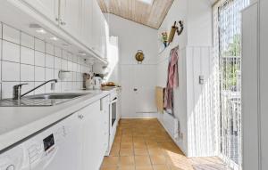 kuchnia z białymi szafkami i zlewem w obiekcie Cozy Home In Mesinge With Wifi w mieście Mesinge