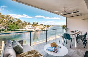 a living room with a view of the water at Jacaranda Noosa in Noosa Heads