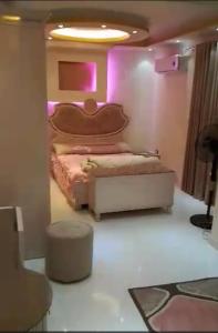 a bedroom with a bed in a room with purple lights at الفايق للشقق الفندقيه 11 in Cairo
