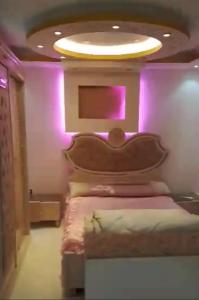 a bedroom with a bed with purple lights on it at الفايق للشقق الفندقيه 11 in Cairo
