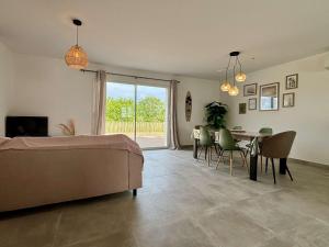 a living room with a bed and a table and chairs at Maison neuve 3 pièces calme sur Oléron proche plage et commerces - FR-1-246A-298 in Dolus d'Oléron