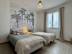 two beds in a bedroom with a mural of palm trees at Maison neuve 3 pièces calme sur Oléron proche plage et commerces - FR-1-246A-298 in Dolus d'Oléron