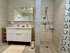 a bathroom with a sink and a shower with a mirror at Maison neuve 3 pièces calme sur Oléron proche plage et commerces - FR-1-246A-298 in Dolus d'Oléron +9 photos