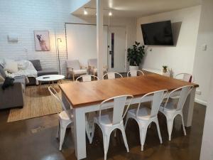 a living room with a wooden table and white chairs at Perfect Large Multi Family Accommodation in Yarrawonga +19 photos