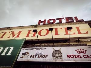 a sign for a hotel with a cat on a building at TM Hotel in Kuala Lumpur