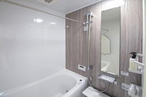 a bathroom with a sink and a toilet and a mirror at 旅タイム・西長堀　駅まで徒歩6分　USJ電車8分 in Osaka