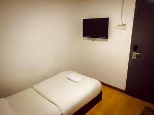 a small room with a bed and a flat screen tv at TM Hotel in Kuala Lumpur