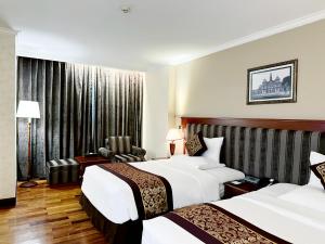 Pokój hotelowy z 2 łóżkami i krzesłem w obiekcie Rex Hotel w Ho Chi Minh