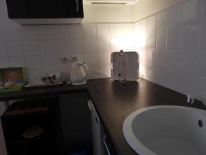 a kitchen with a sink and a counter with a counter at B&B Le Miroir aux Fées Bordeaux in Bordeaux