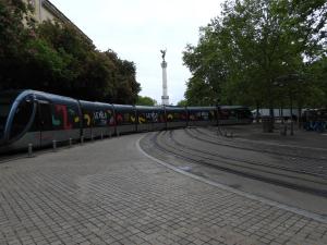 a train on the tracks with a tower in the background at B&B Le Miroir aux Fées Bordeaux in Bordeaux