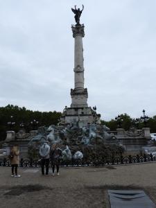 people standing around a statue in front of a monument at B&B Le Miroir aux Fées Bordeaux in Bordeaux