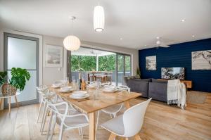 a dining room and living room with a table and chairs at Jacaranda Noosa in Noosa Heads
