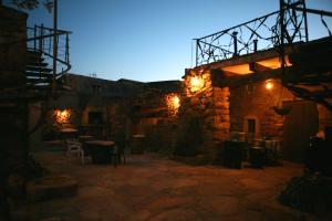 a stone building with a patio at night at Hotel Rural Bermellar in Bermellar